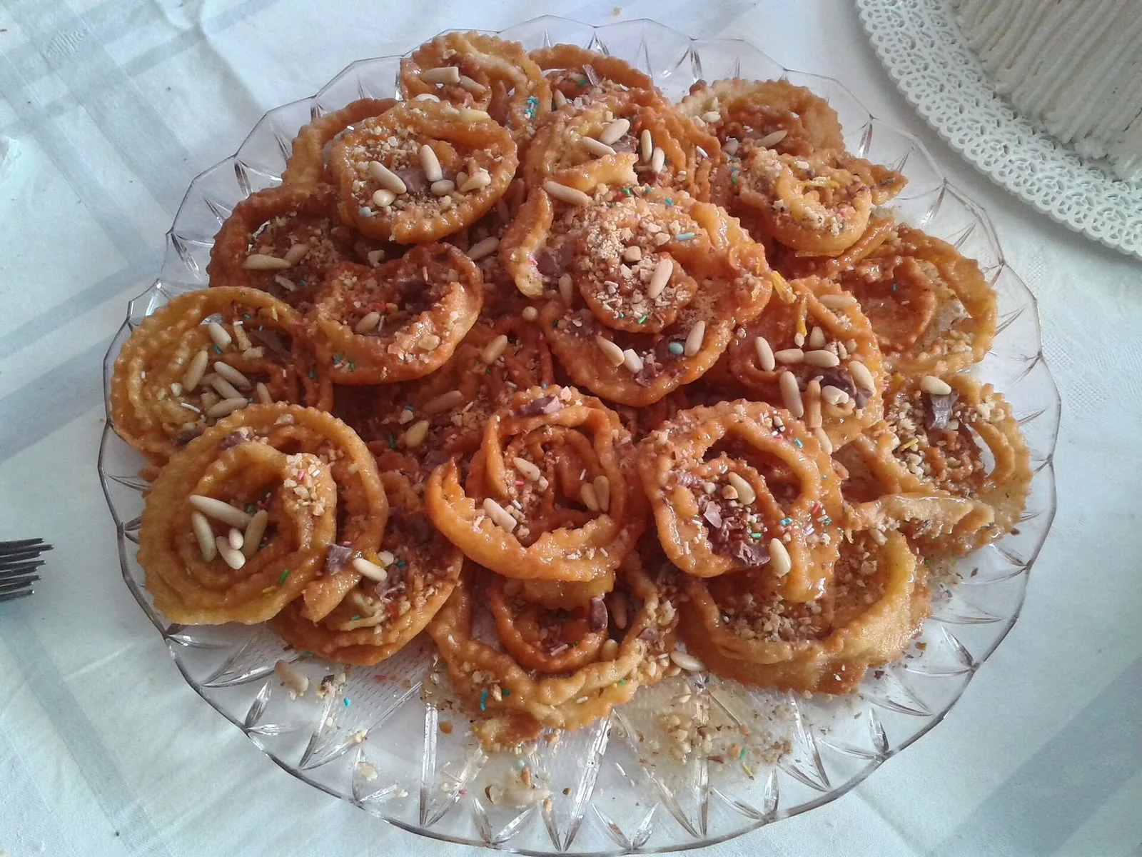 Piatto di cartellate al miele con pinoli, dolce tipico del Natale pugliese